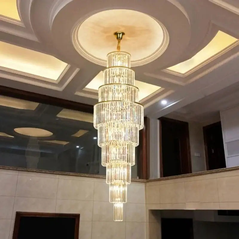 A multi-tiered DecorBites™ led rotating staircase chandelier with clear crystals and gold finish for villa décor