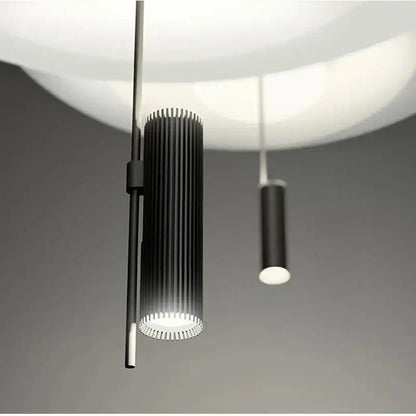 Black cylindrical pendant light with vertical ridges and glowing white base from DecorBites led saucer pendant collection