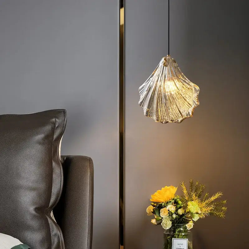 Decorbites led shell pendant light is a translucent ridged glass pendant light with warm golden lighting shaped like a seashell