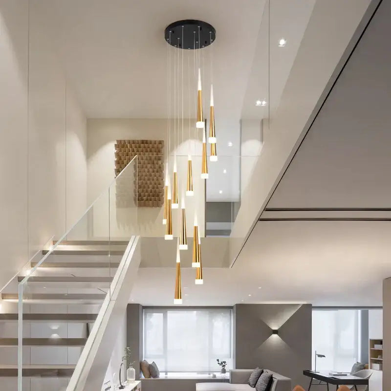 Modern gold-toned decorbites led spiral chandelier with tapered cylindrical shades and black ceiling mount for stairwell lighting