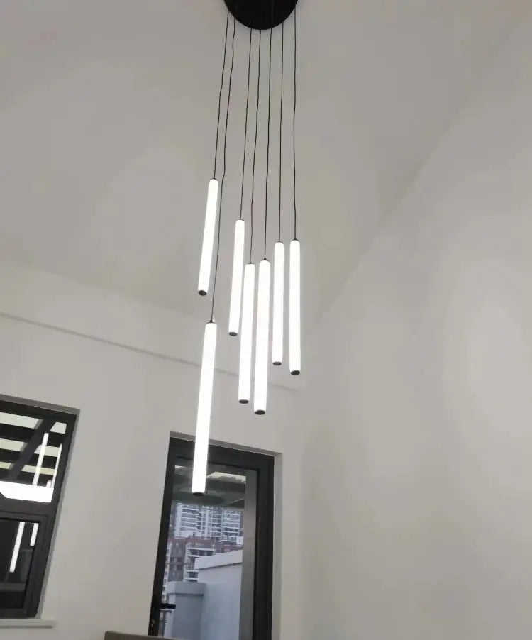 Modern black circular DecorBites™ LED spiral staircase chandelier with multiple slender white cylindrical light tubes