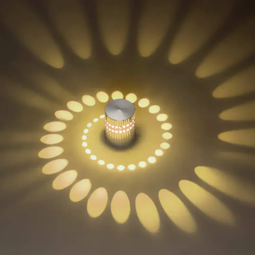 A sleek cylindrical decorbites led spiral wall light with brushed metallic finish and warm yellow radial patterns