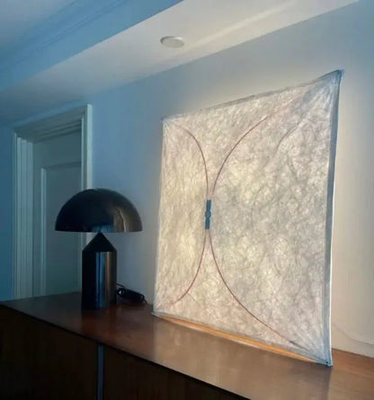 A decorbites led square fabric wall lamp with a textured off-white surface and subtle curved lines for modern interiors