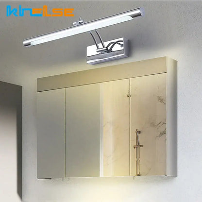 Chrome finished decorbites led stainless steel bathroom wall lamp with adjustable arms mounted above mirrored medicine cabinet