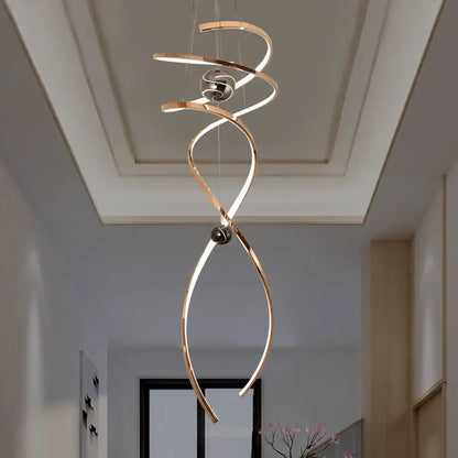 A modern gold-toned decorbites led staircase pendant light with metallic rings and black spherical accents