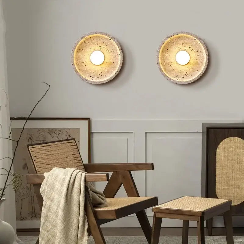 Two circular decorbites led stone wall lamps with textured beige stone finish and warm glowing centers for home decor