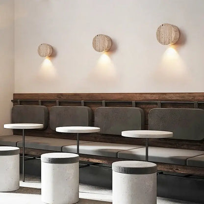 Three circular wooden wall lamp sconces with a natural rustic finish by DecorBites LED stone wall for modern interior use