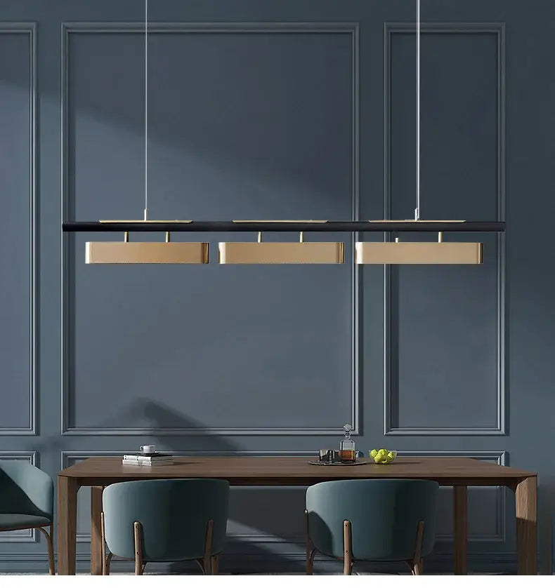 Modern minimalist strip led pendant lights with three gold rectangular fixtures on a black bar for dining rooms