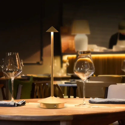 Gold-colored decorbites™ led table lamp with sleek triangular top and cylindrical base for ambient room lighting