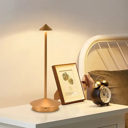Gold-toned DecorBites™ led table lamp with slender stem conical shade circular base cordless touch sensor bedside light