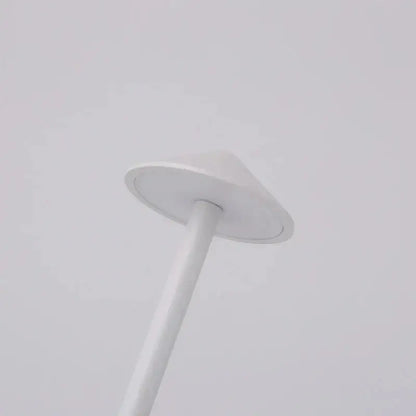 A sleek white cordless led table lamp with a conical shade and cylindrical pole for ambient bedside lighting