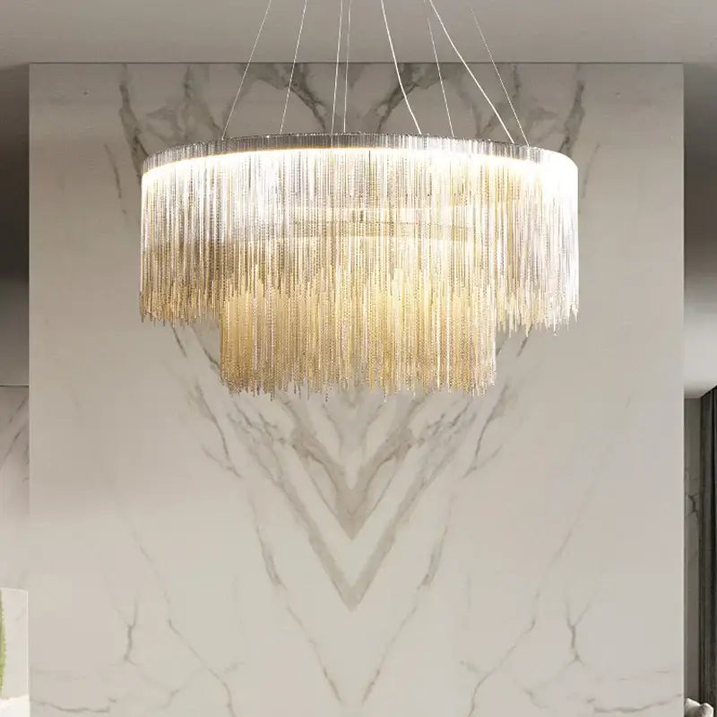 A modern decorbites led tassel chandelier pendant light with cascading golden metallic fringe and illuminated silver frame