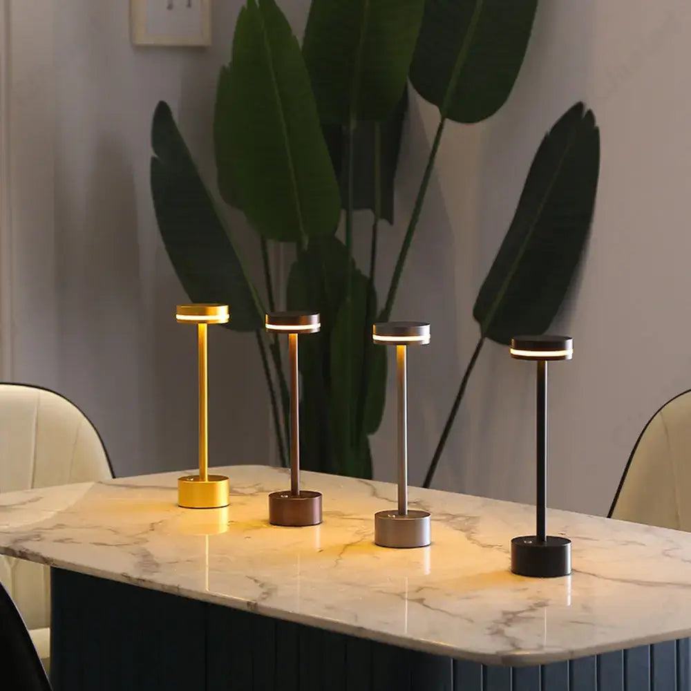 Four minimalist table lamps in gold bronze silver and black on marble surface decorbites led touch table lamp