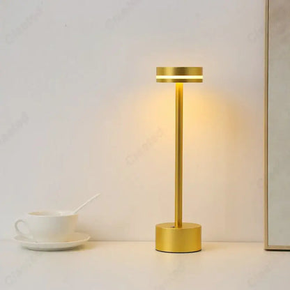 Gold-colored DecorBites LED touch table lamp with sleek cylindrical design and warm ambient rechargeable lighting for living room