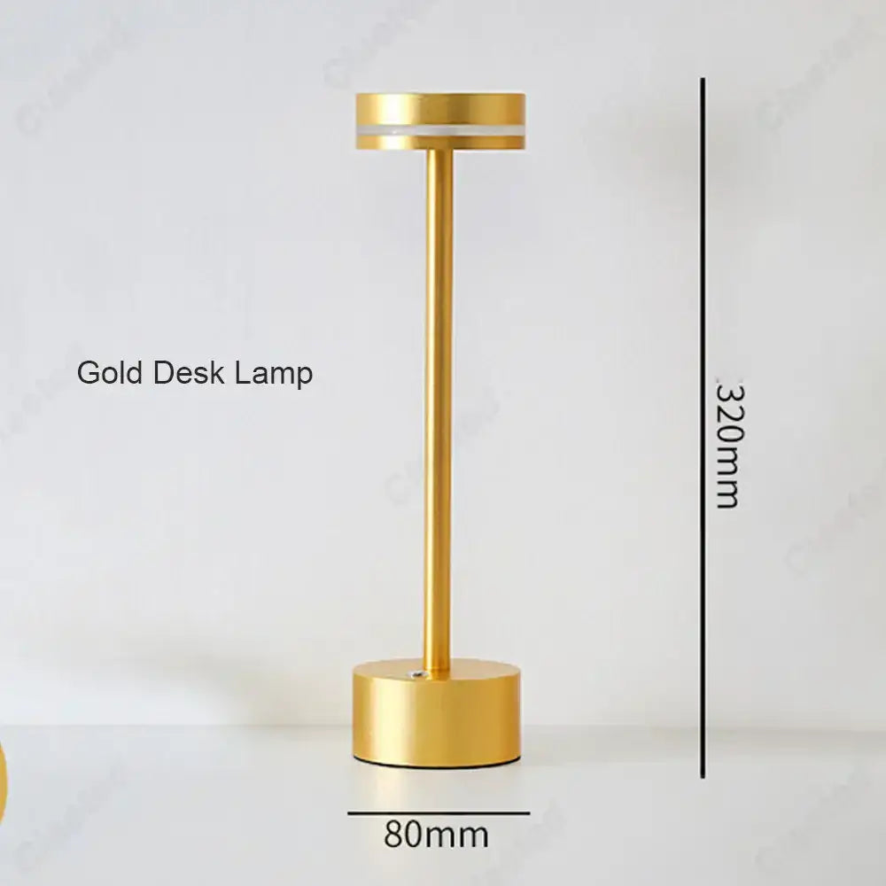 A sleek minimalist gold decorbites led touch table lamp with cylindrical base and slender stem for living room use