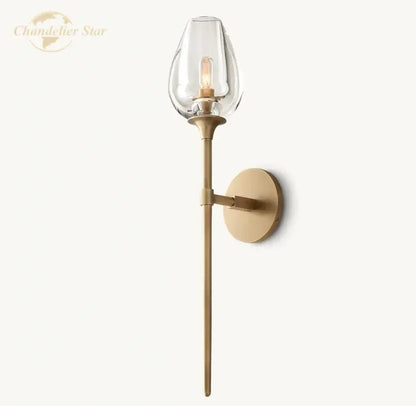 A sleek brass decorbites led tulip wall sconce with clear glass teardrop shade and exposed filament bulb for indoor use