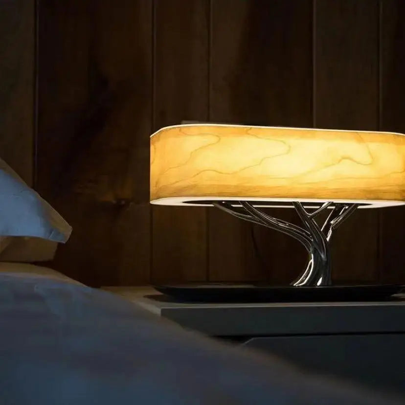 DecorBites™ Light of Life table lamp with warm amber light, sleek tree-shaped metallic base, and translucent wooden shade