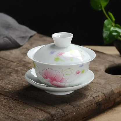 A delicate white porcelain gaiwan tea set with hand-painted pink floral design and green vines by decorbites lotus