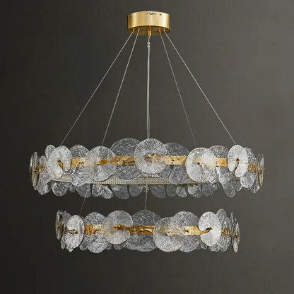 A decorbites lotus leaf two-tiered led chandelier with clear textured glass discs and brass finish for living room lighting
