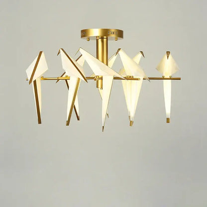 Gold-toned decorbites love bird chandelier with origami-style white paper birds and illuminated interiors for dining room
