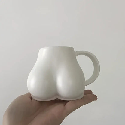 White ceramic coffee cup shaped like buttocks with glossy finish and curved handle from decorbites lovely butt shape collection