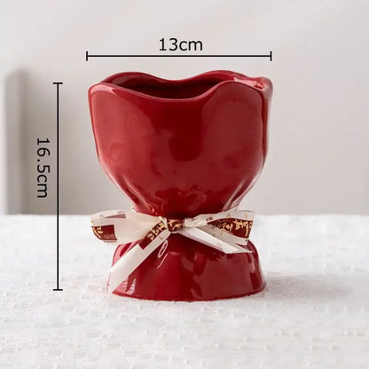 A glossy red ceramic vase shaped like a tulip from the decorbites lovely ribbon vase set with a white and gold ribbon