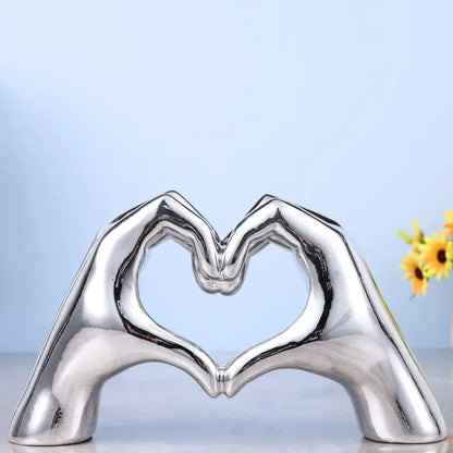 Shiny silver ceramic decorbites loving gesture heart sculpture of two hands forming a loving gesture heart for decor