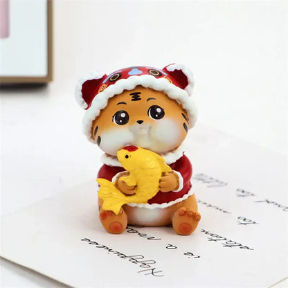 Cute orange lucky tiger figurine wearing a red and white santa hat holding a yellow fish miniature home decor