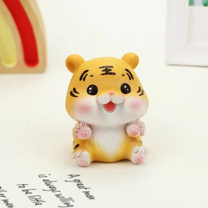 Decorbites™ lucky tiger figurine in yellow with black whisker markings and pink cheeks sitting on a white surface
