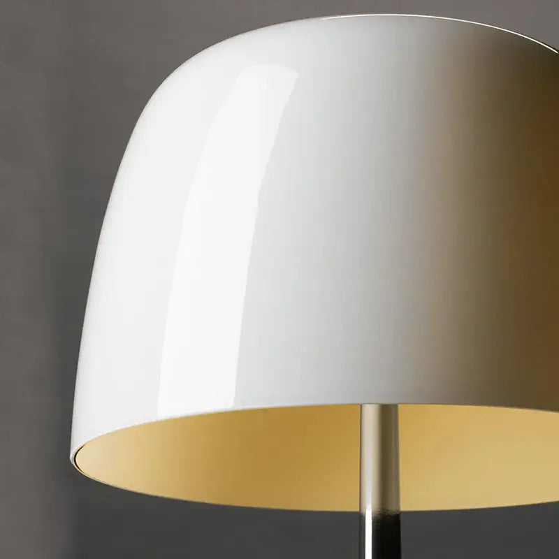 White glossy lampshade with gold interior and sleek metallic stem in a decorbites lumiere table lamp for modern living rooms