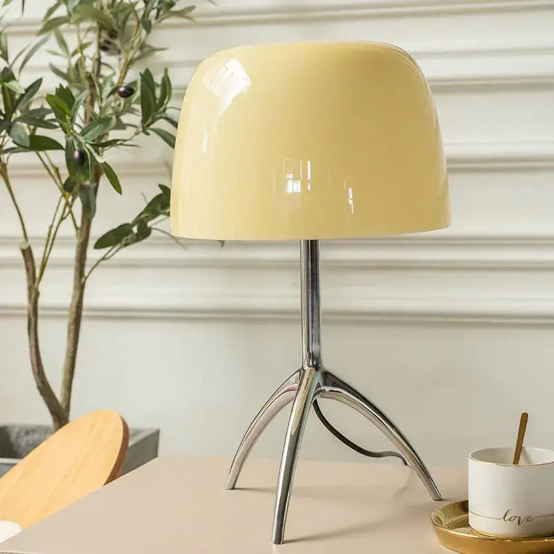 Cream-colored glossy decorbites lumiere table lamp with sleek chrome tripod base ideal for bedroom and living room use
