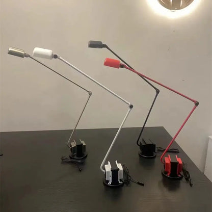 Three decorbites lumina floor lamps with long adjustable metal arms and colored heads in white black and red for study use