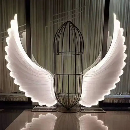 A decorbites luminescent angel wings led lamp with glowing white led wings and a black wire cage body for modern decor