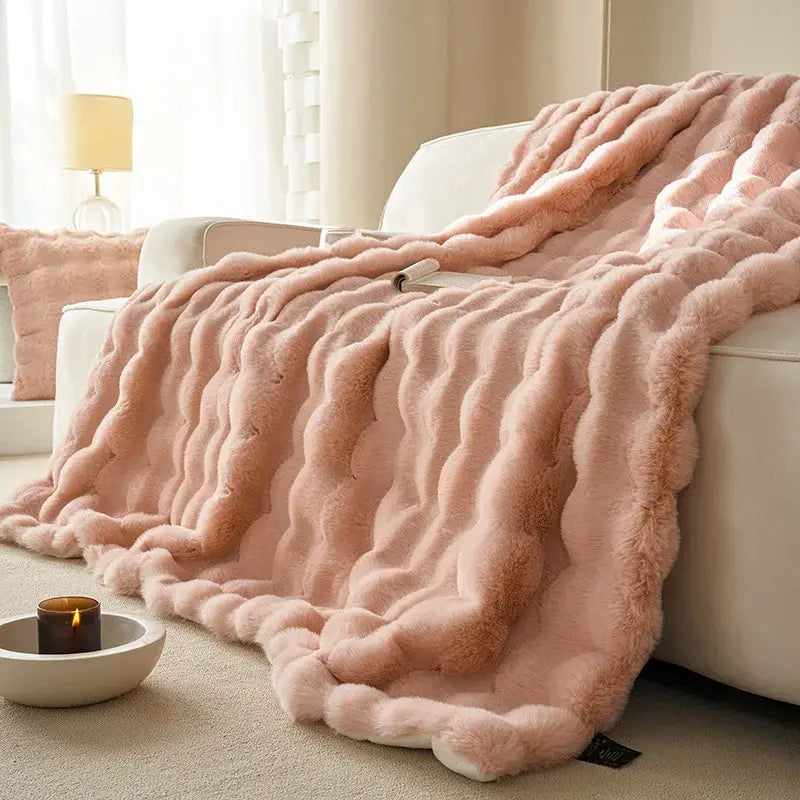 A soft pink decorbites luxe faux rabbit fur throw blanket with wavy ribbed texture for cozy autumn winter use