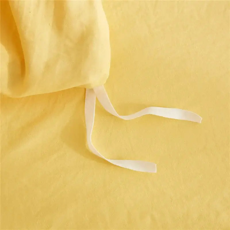 Soft yellow linen bedsheet with white elastic ties from decorbites luxe furball tasseled bedding set queen king size