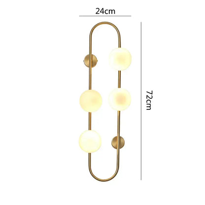 Gold-toned decorbites luxe glass wall sconce with three frosted glass spheres on a curved metal frame for modern rooms