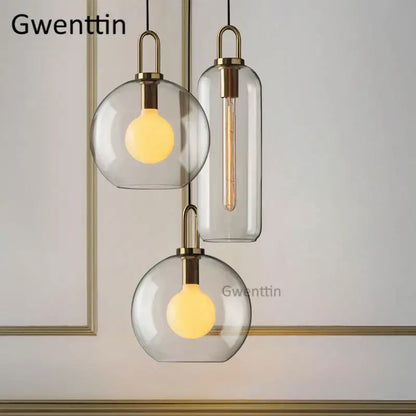 Modern brass-finished decorbites luxe glass ball pendant lights with clear glass shades and warm-toned led bulbs