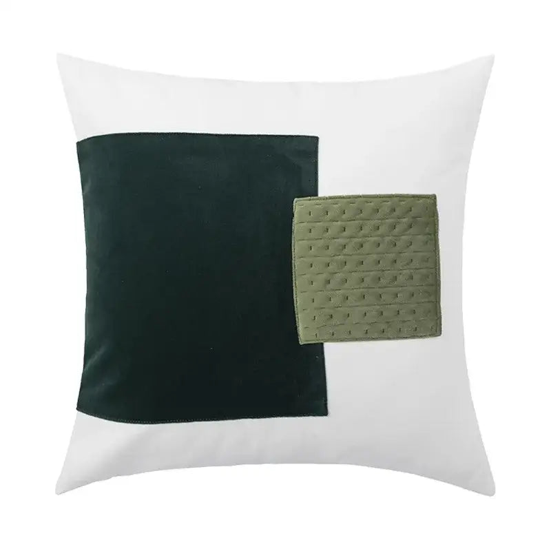 White cushion cover featuring a large dark green velvet square and an olive-green quilted patch by decorbites luxe gray