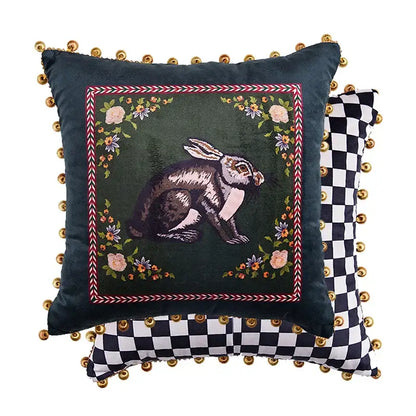 Dark green velvet decorative pillow cover with embroidered rabbit floral motifs red white border and gold pom-poms