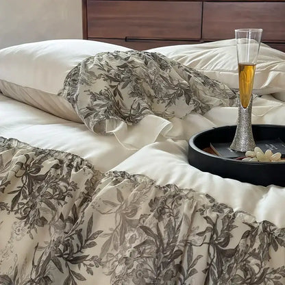 A champagne flute with a diamond-encrusted stem on a black tray beside the decorbites luxe lace ruffles bedding set