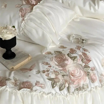 White satin bedding set with delicate pink and beige floral embroidery and ruffled edge from decorbites luxe lace ruffles collection