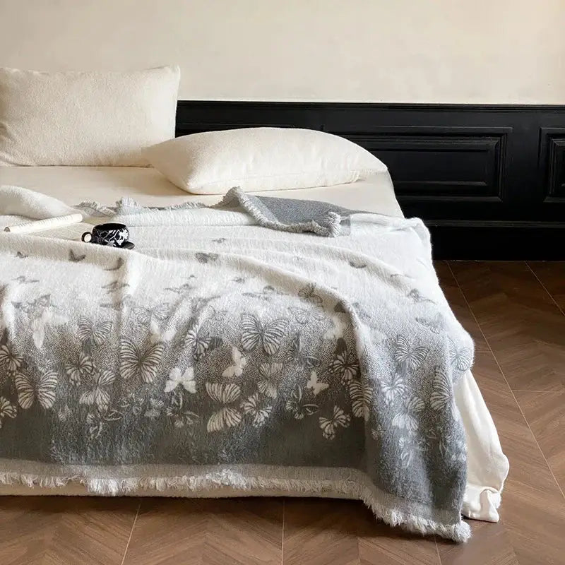 Soft gray DecorBites Luxe mink fur jacquard throw blanket with delicate butterfly pattern and frayed edges for cozy warmth
