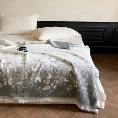 Soft gray DecorBites Luxe mink fur jacquard throw blanket with delicate butterfly pattern and frayed edges for cozy warmth