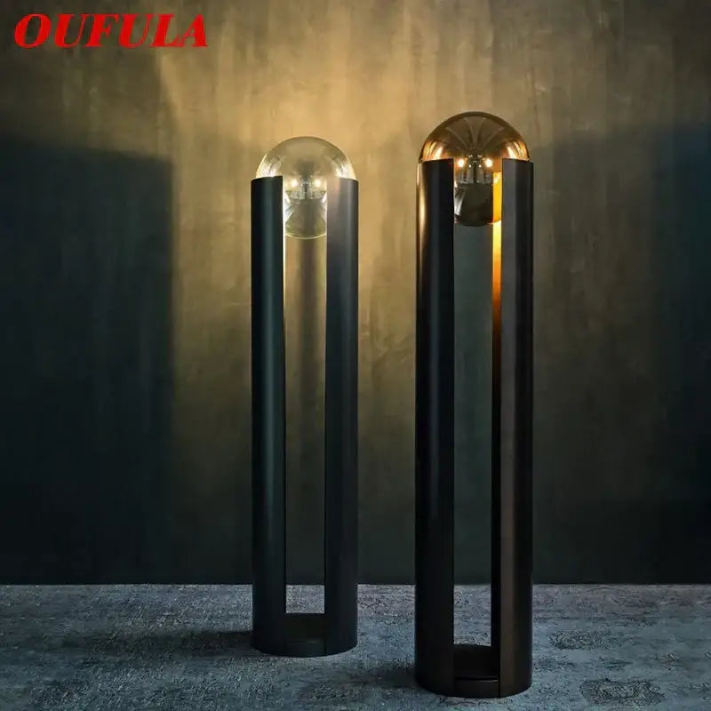 Two decorbites luxe nordic floor lamps with sleek black cylindrical bases and spherical clear and gold-toned glass tops