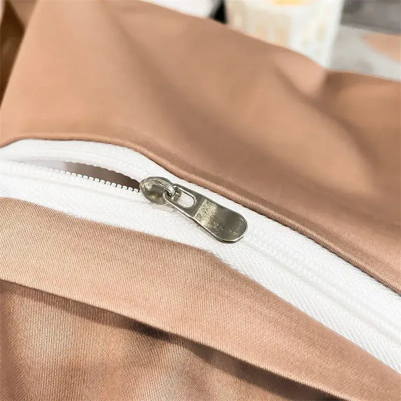 A sleek metallic zipper with a silver pull on taupe egyptian cotton fabric of decorbites luxurious duvet cover