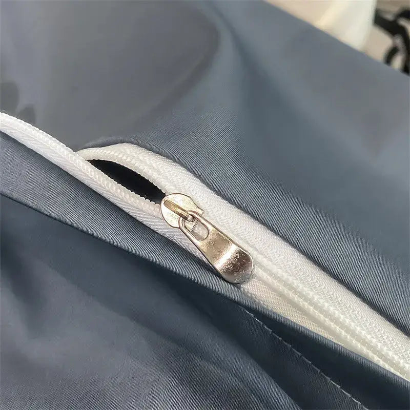 A sleek silver zipper with metallic pull tab on the seam of a dark gray 1000TC egyptian cotton duvet cover piece