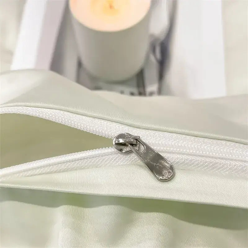 A sleek silver zipper with metallic pull tab on pale green satin DecorBites™ luxurious 1000TC cotton duvet cover