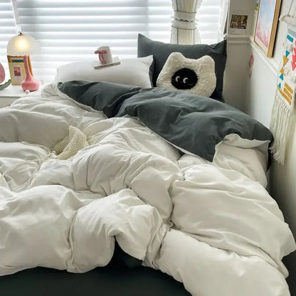 A plush white cat-shaped pillow on a dark gray cotton bedding set from decorbites luxurious duvet cover collection