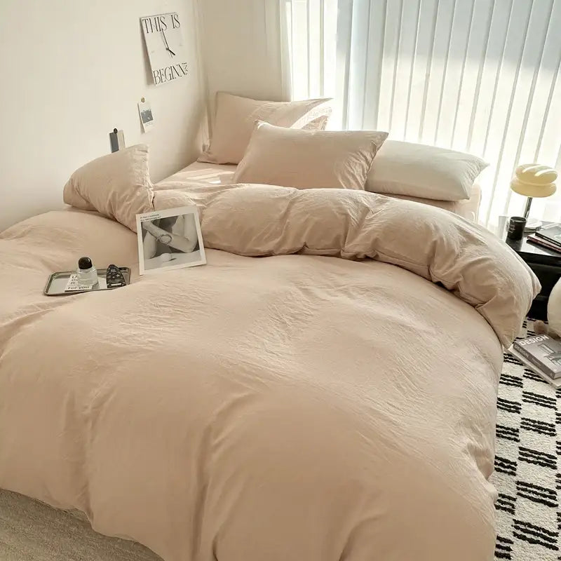 Beige soft-textured cotton bedding set with matching pillows neatly arranged on a bed by decorbites™