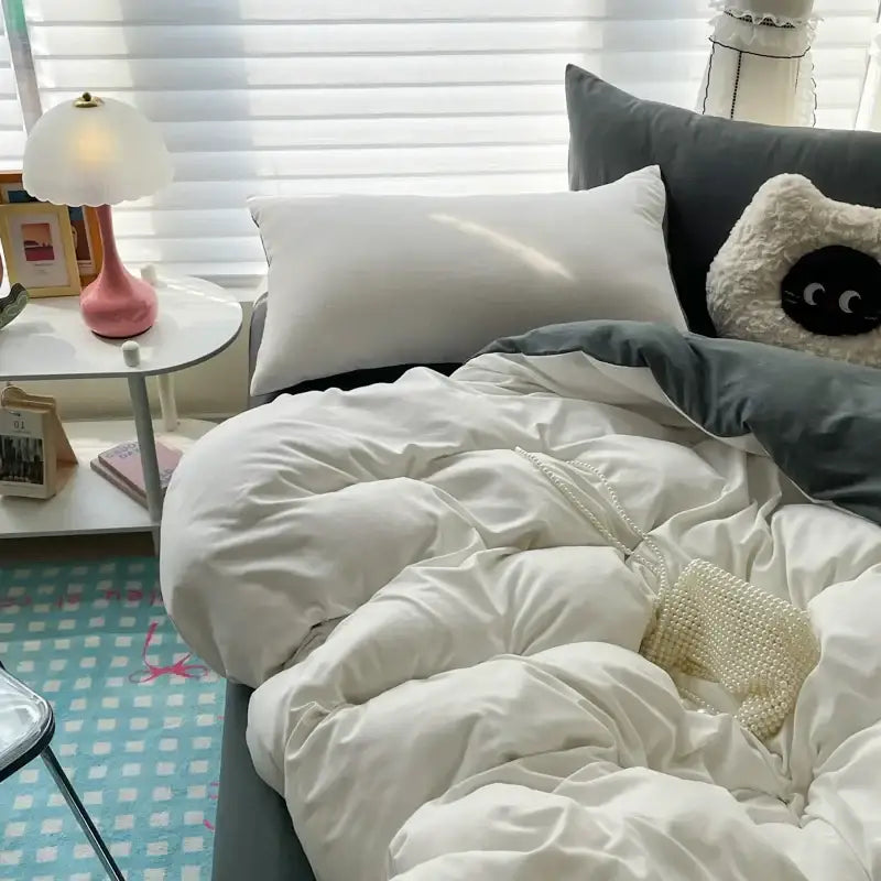 A cream-colored beaded mesh handbag resting on a white duvet cover from the decorbites luxurious bedding set